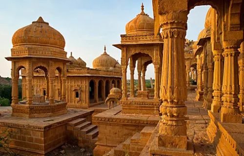 The royal cenotaphs of historic rulers, also known as Jaisalmer Chhatris, at Bada Bagh in Jaisalmer made of yellow sandstone at sunset